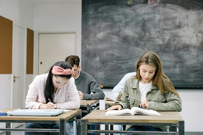 students sitting by the table in the classroom